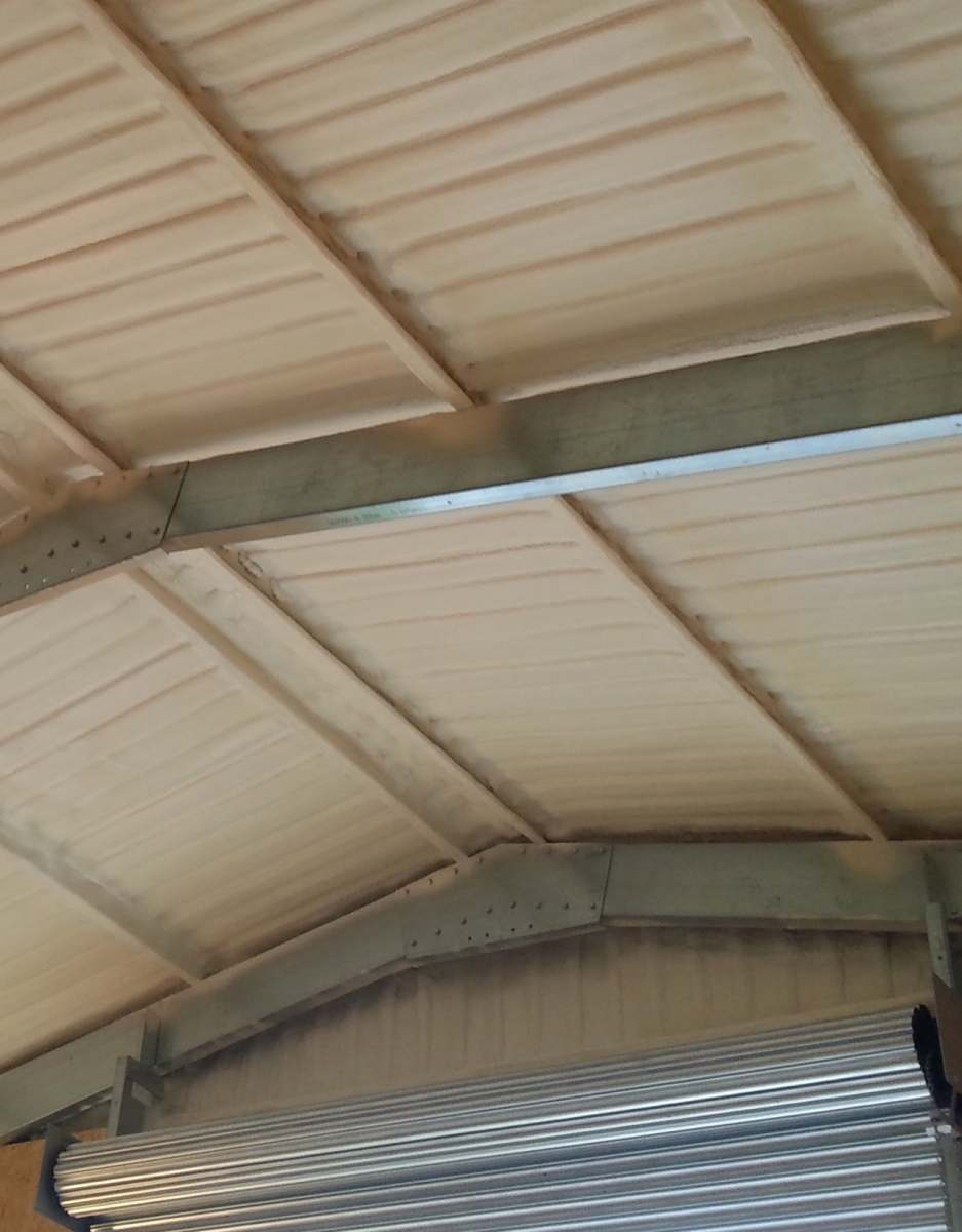 Image showing spray foam applied to metal roof cladding in warehouse by Isotech Sprayfoam